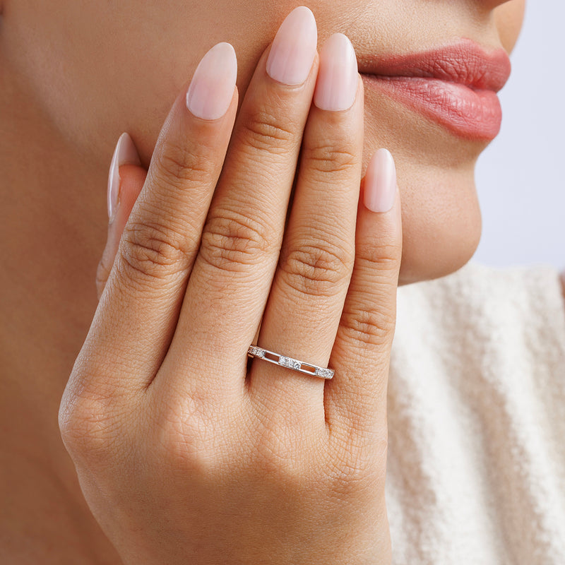 A person with manicured nails touches their face, wearing the Keemti Jewels MINIMAL Channel Set RING on their finger.