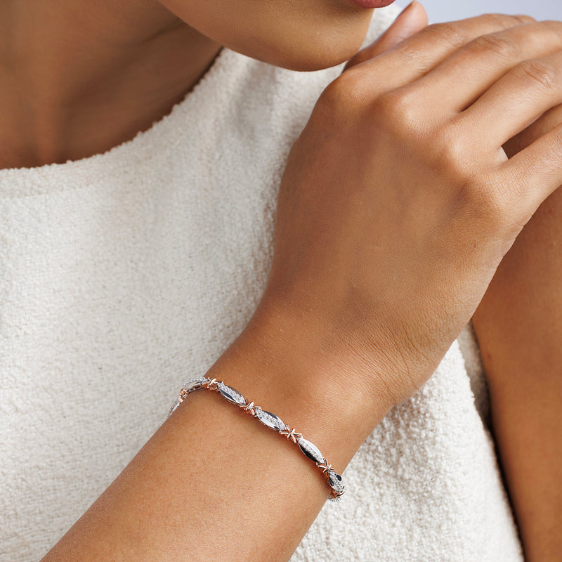 A woman in a textured white top wears the Keemti Jewels MARQUISE Bloom BRACELET, silver and gold with marquise links.