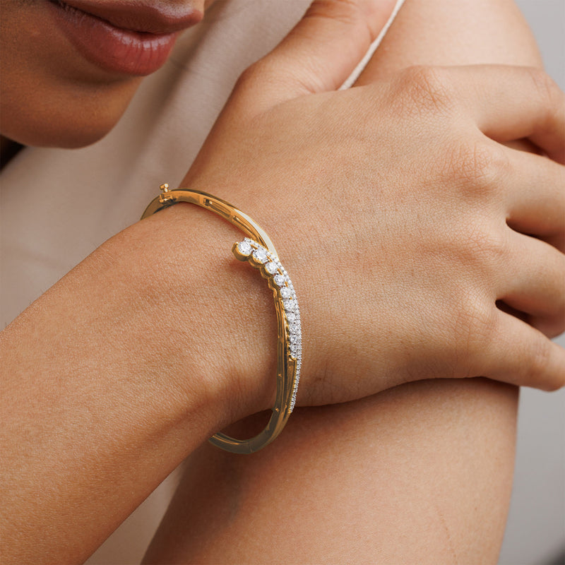 Close-up of a person wearing the Keemti Jewels Crescent Spark Oval Bracelet, a luxury gold piece with sparkling gems.