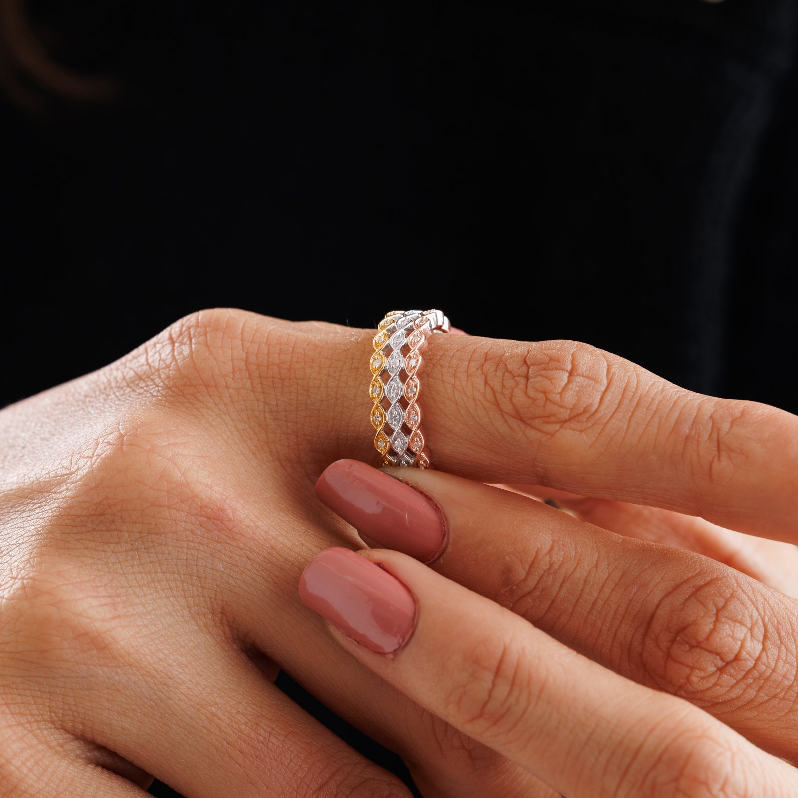 On-hand three-tone braid diamond ring with round pavé stones, snug stacked band