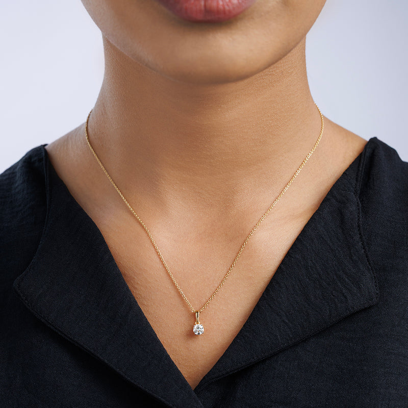 A woman wears Keemti Jewels' TIMELESS Round Solitaire NECKLET with a classic black top.