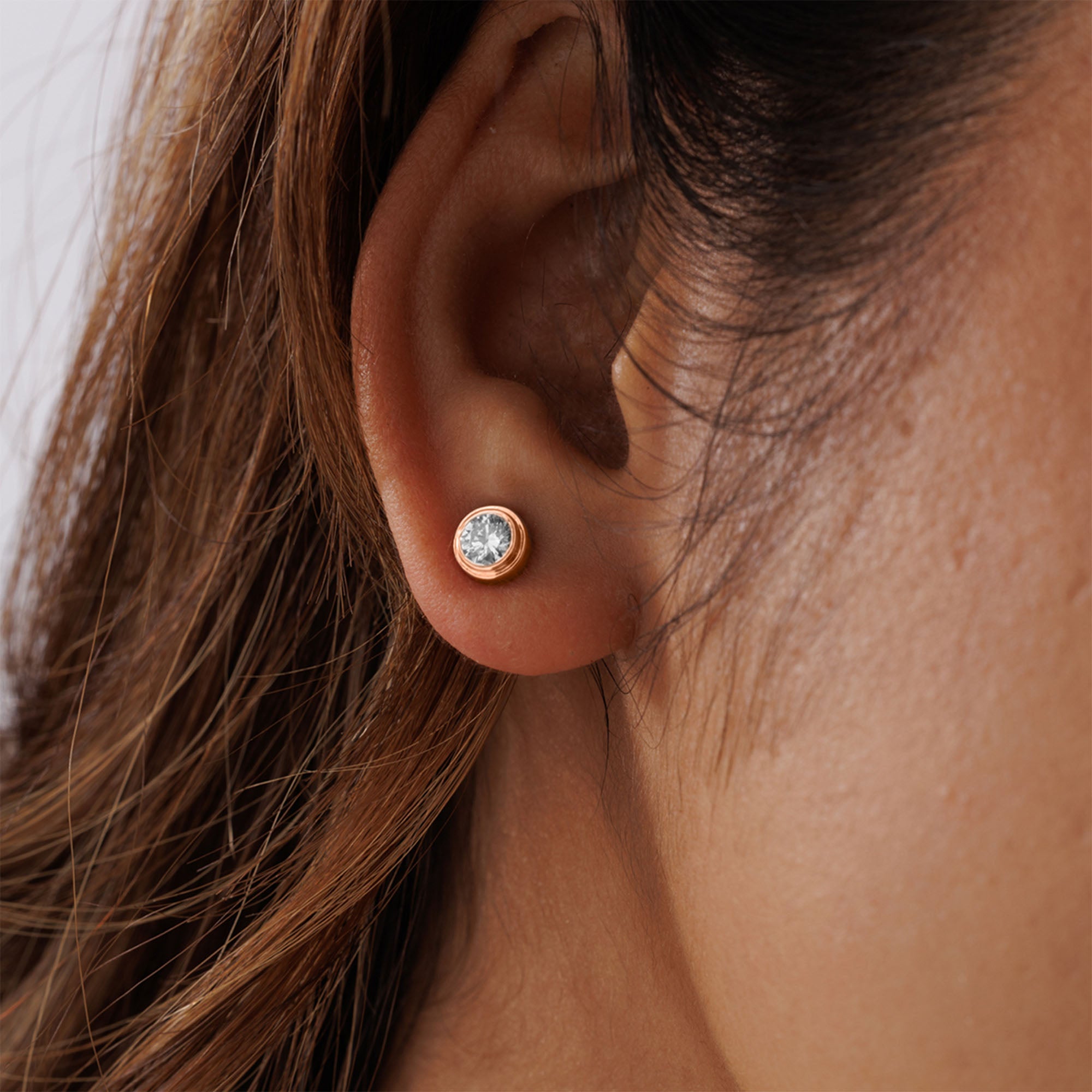 A close-up of an ear wearing Keemti Jewels' Classic Bezel Stud Earrings—ideal for modern, minimalist everyday style.