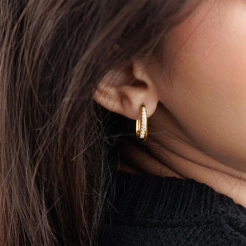 A close-up of a woman's ear wearing Keemti Jewels' Classic Shine Hoop Earrings with a diamond stripe accent.