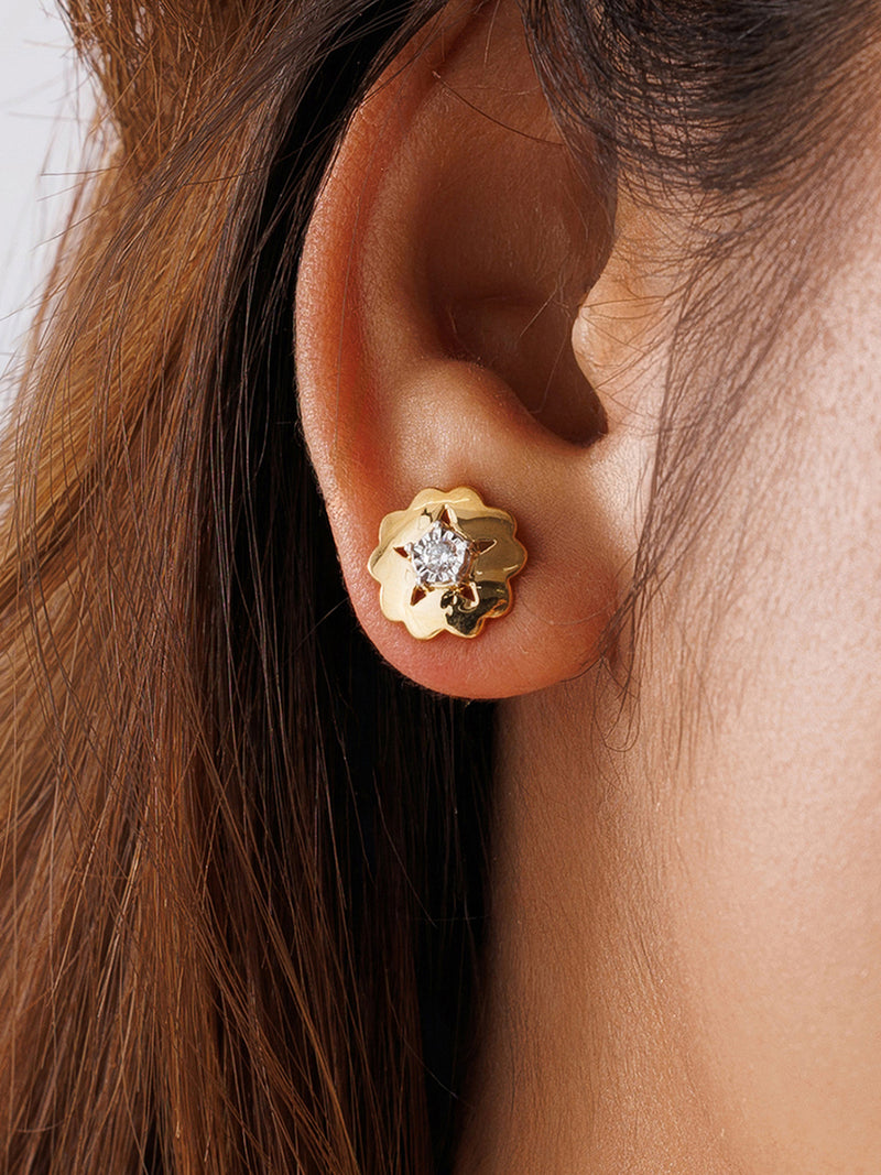 Worn starburst floral stud earrings with round clear stone on gold-tone backing