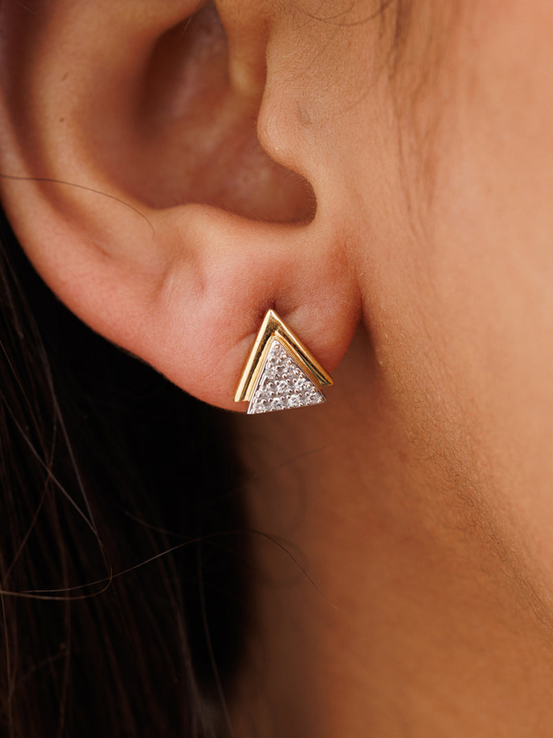 Triangle spark stud earrings on ear: gold border with silver glitter pavé triangle