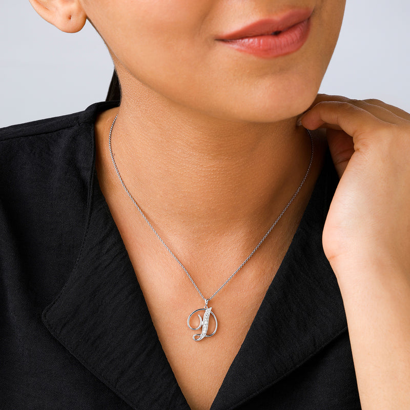 Woman wearing Keemti Jewels CLASSIC D Signature PENDANT, smiling softly with her hand near her neck.
