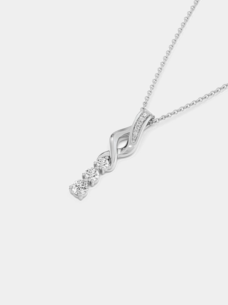 Three-stone twirl drop necklace on neckline: silver chain with sparkling swirl pendant