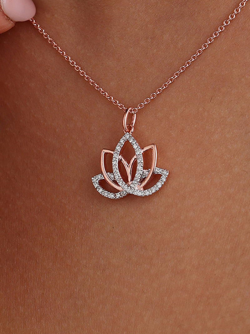 Rose-gold lotus pendant on a delicate chain, resting on the neckline