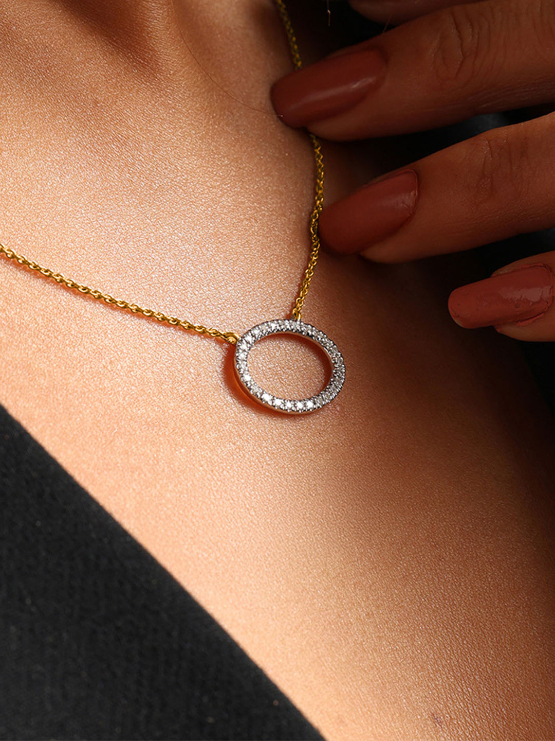 Close-up of a woman in black wearing Keemti Jewels' Classic Oval Halo Necklet with a diamond oval pendant.
