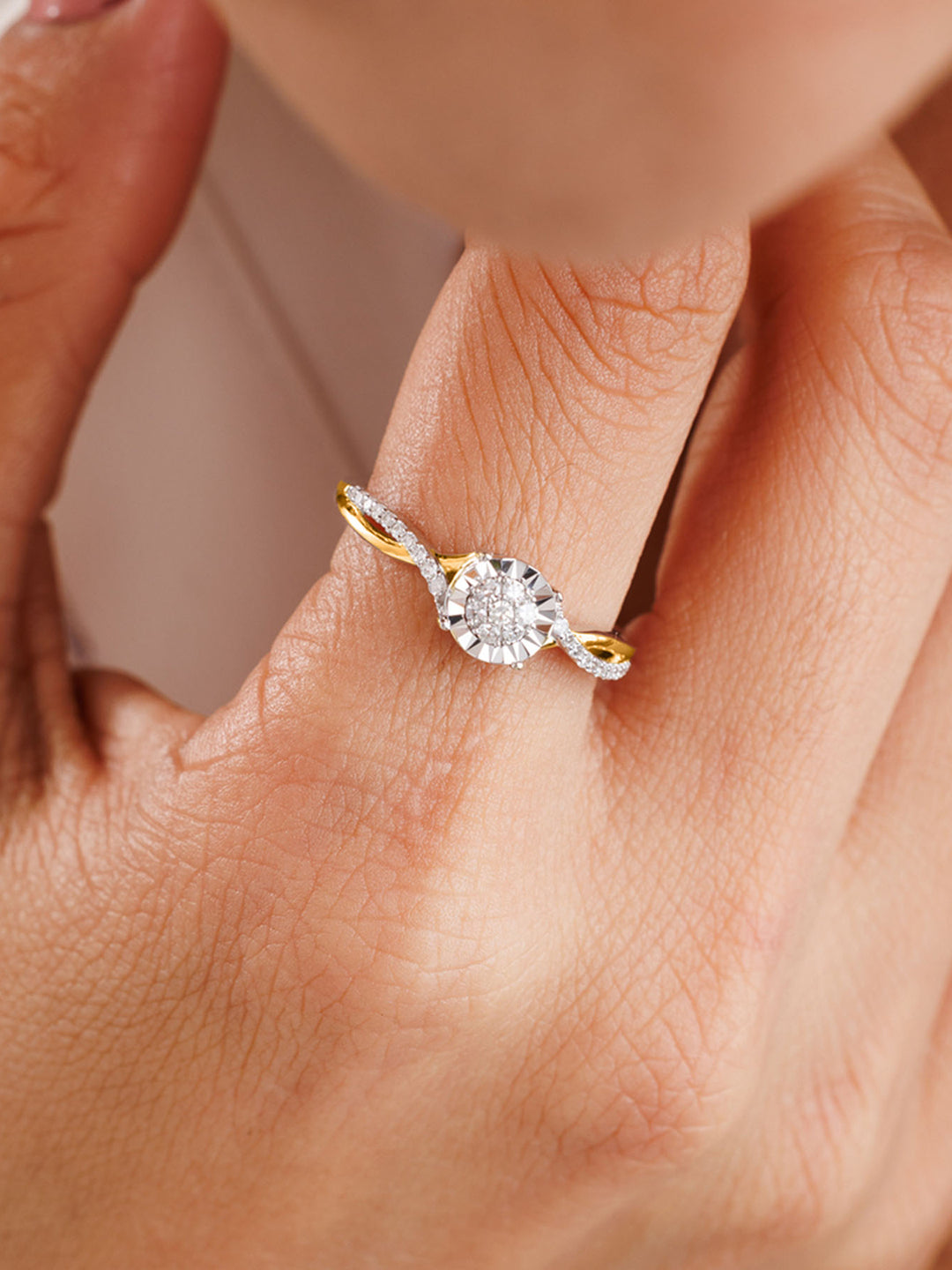 A hand wears Keemti Jewels' Classic Round Twist Band Ring, a gold diamond piece with a twisted shank, on the ring finger.
