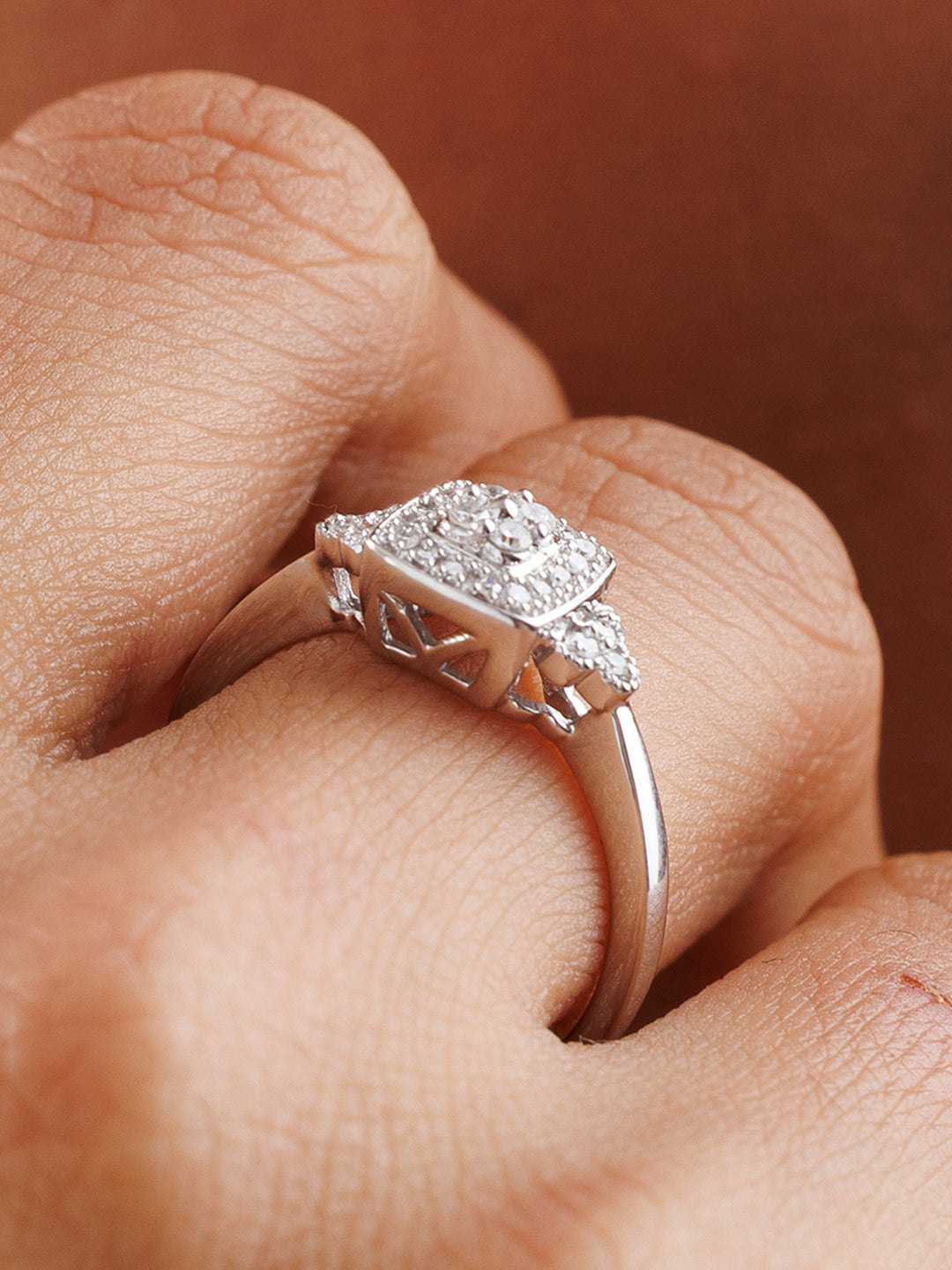 Diamond cluster ring on hand, cushion-shaped halo with split shank details