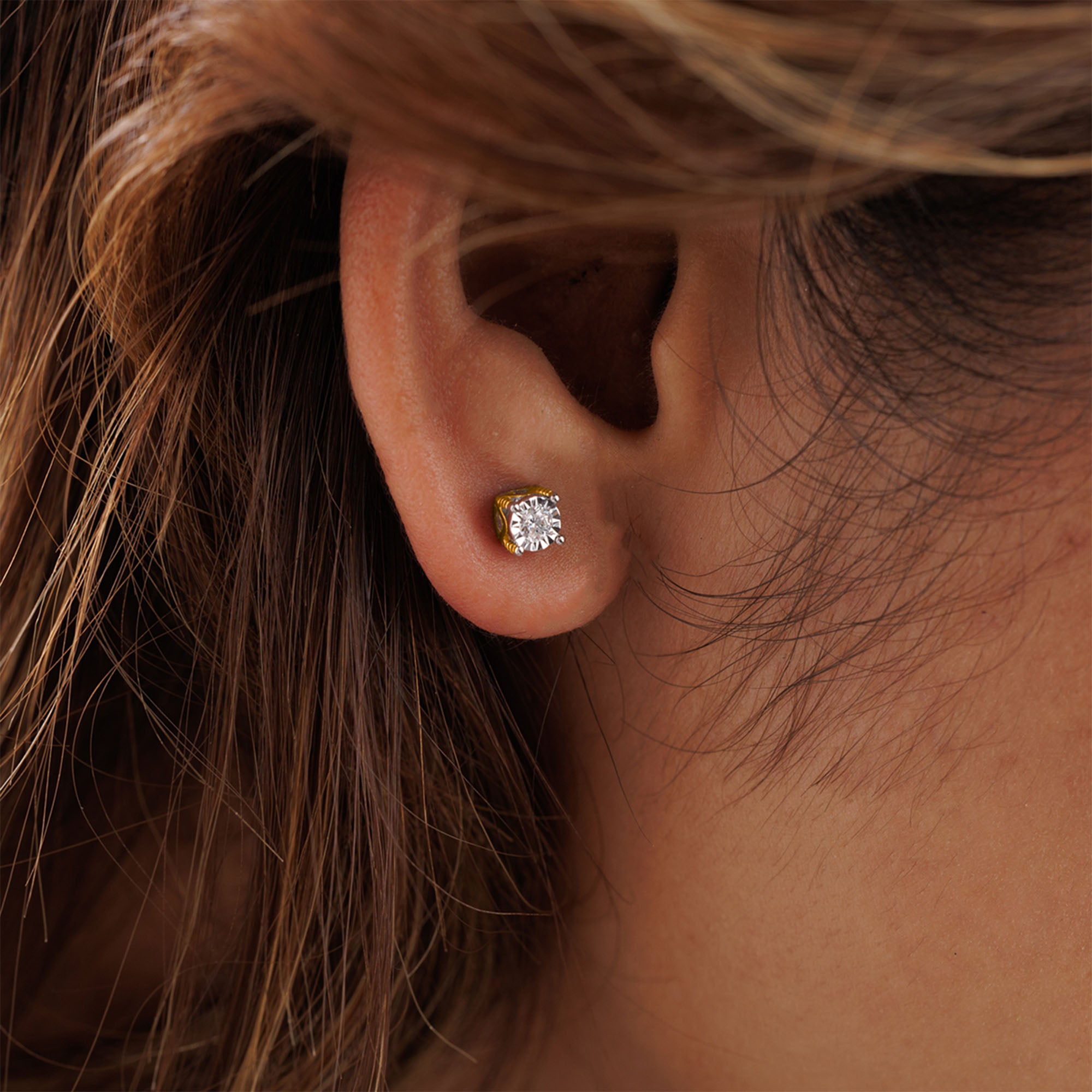 An ear with brown hair wears Keemti Jewels’ Minimal Round Cut Solitaire Stud Earring in a close-up shot.