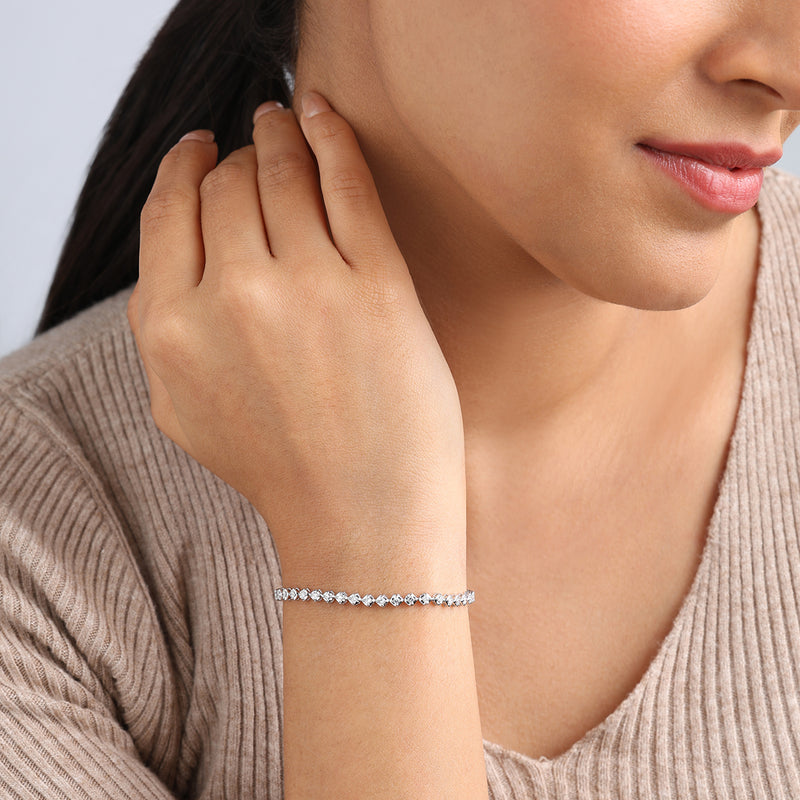 A woman in a beige ribbed top showcases Keemti Jewels' Classic Oval Links Diamond Bracelet on her wrist.