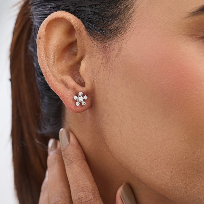 Close-up of a woman wearing Keemti Jewels’ Floret Diamond Stud Earrings, touching her neck with manicured fingers.
