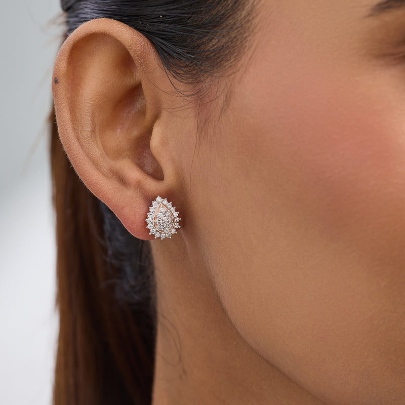 Close-up of a woman's ear wearing Keemti Jewels Soft Blush Pear Diamond Stud Earrings, ideal for elegant workwear.