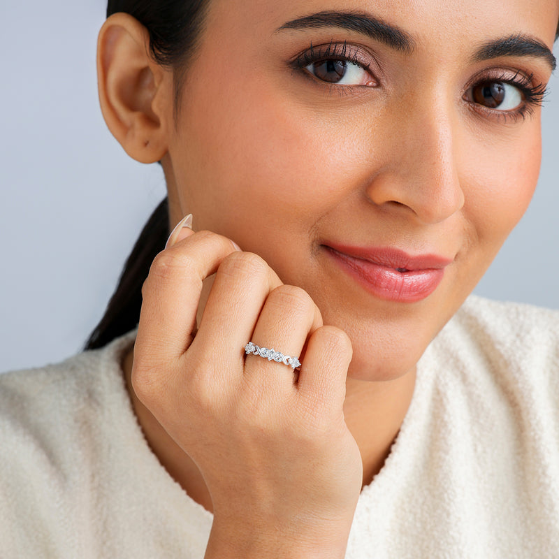 A woman smiles, wearing Keemti Jewels’ Interlock Cluster Diamond Ring on her left hand with a cream-colored top.