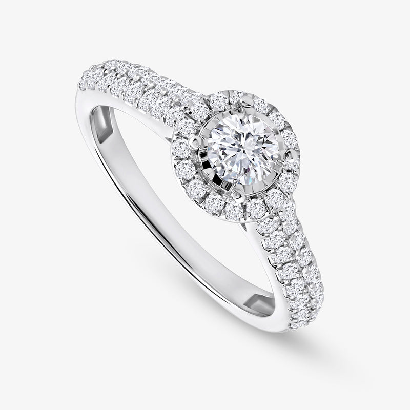 Keemti Jewels’ Timeless Halo Of Love Diamond Ring features a round center, halo, and diamond-accented band.