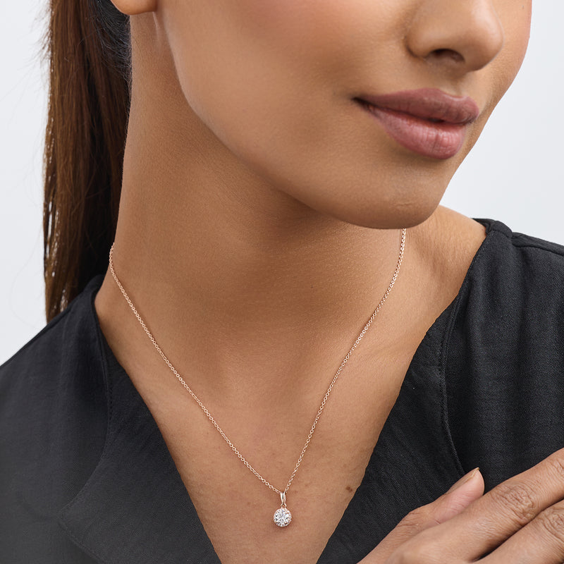 A woman wears Keemti Jewels’ AURELIA Round Halo NECKLET, exuding everyday elegance in a black top, shown shoulders-up.