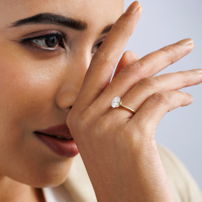 Woman with hand near face wears Keemti Jewels MINIMAL Oval Solitaire RING featuring a luminous, oval centerpiece.