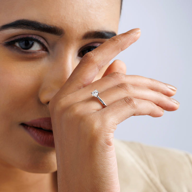 A woman poses, hand near her face, wearing the ELEGANT Round Solitaire RING by Keemti Jewels.